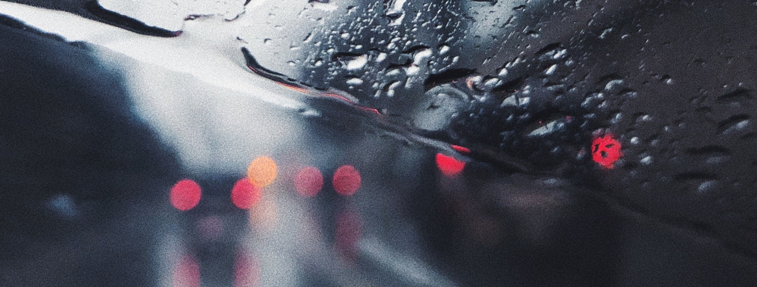 Widok przez szybę samochodową podczas intensywnych opadów deszczu. 